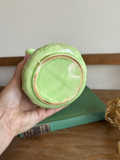The base of an English Majolica style green cabbage leaf textured jug.  