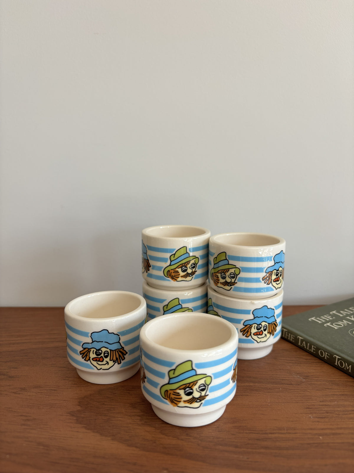 Six small Vintage Hornsea ceramic cups with blue and white stripes and whimsical faces wearing hats. 