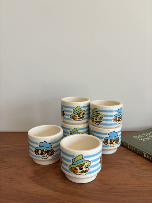Six small Vintage Hornsea ceramic cups with blue and white stripes and whimsical faces wearing hats. 