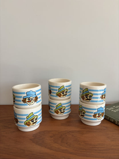 Six small Vintage Hornsea ceramic cups with blue and white stripes and whimsical faces wearing hats. 