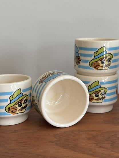 Six small Vintage Hornsea ceramic cups with blue and white stripes and whimsical faces wearing hats. 