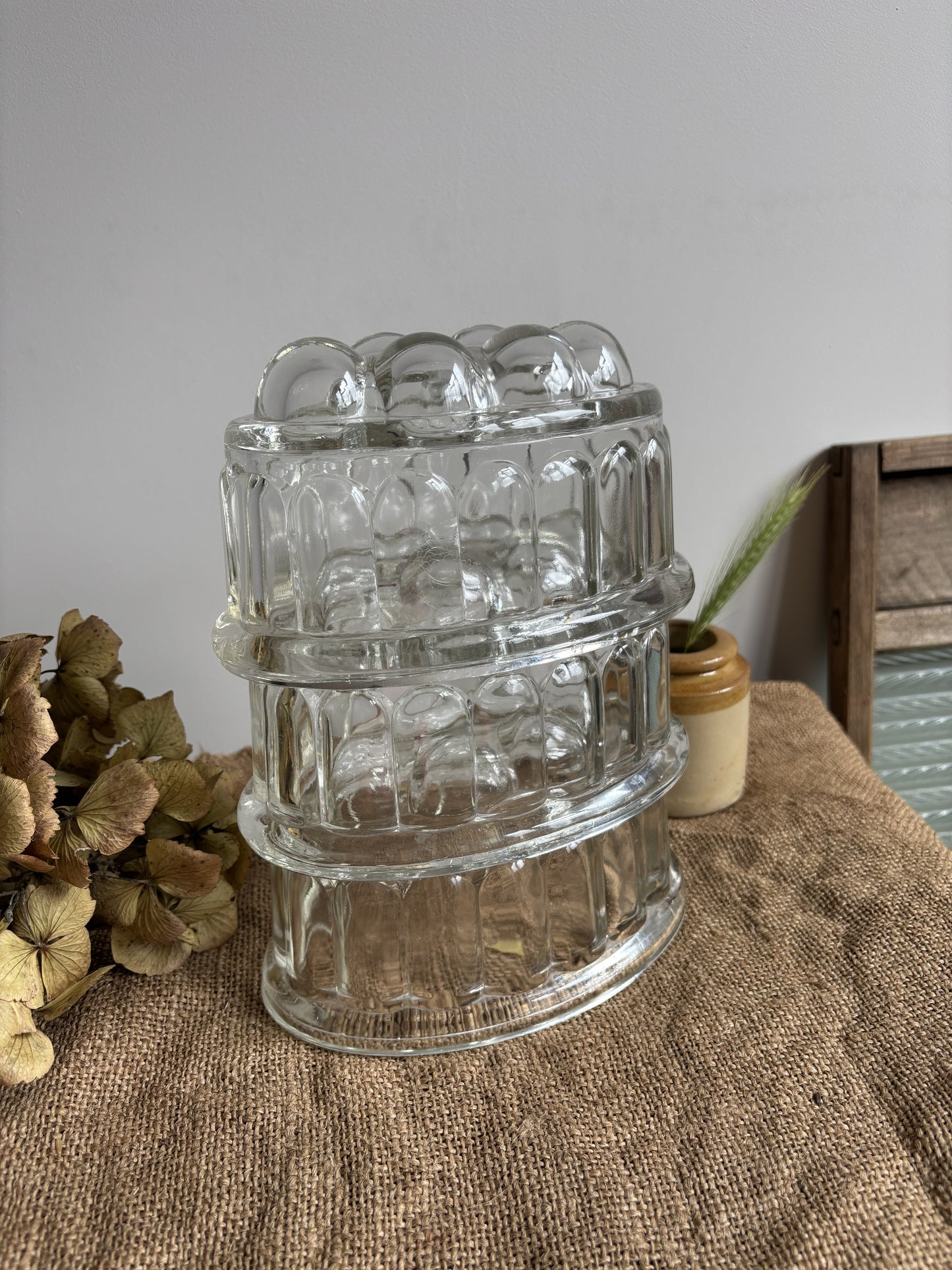 Clear glass container with textured design on a textured surface