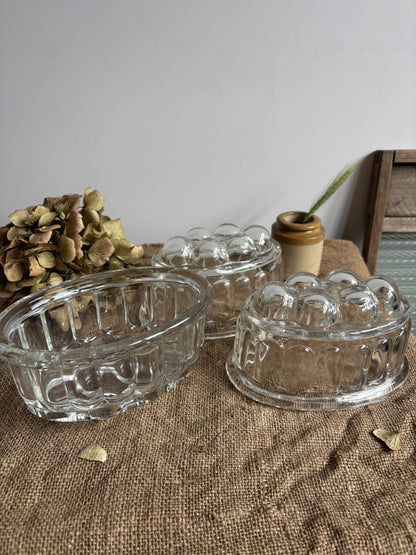 Three clear glass bowls on a textured surface with a neutral background