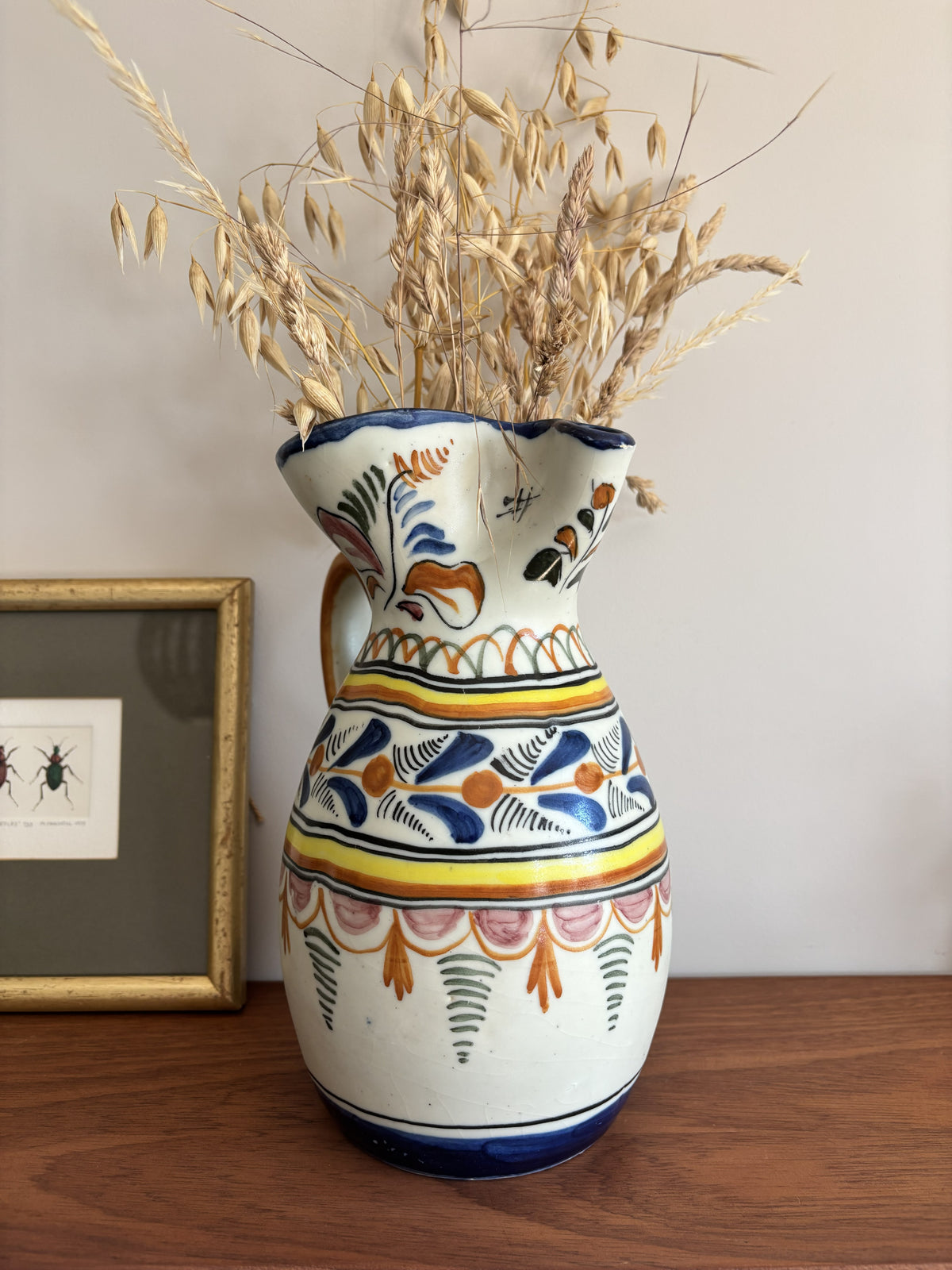 A large Spanish stoneware pitcher featuring vibrant colourful motifs 
