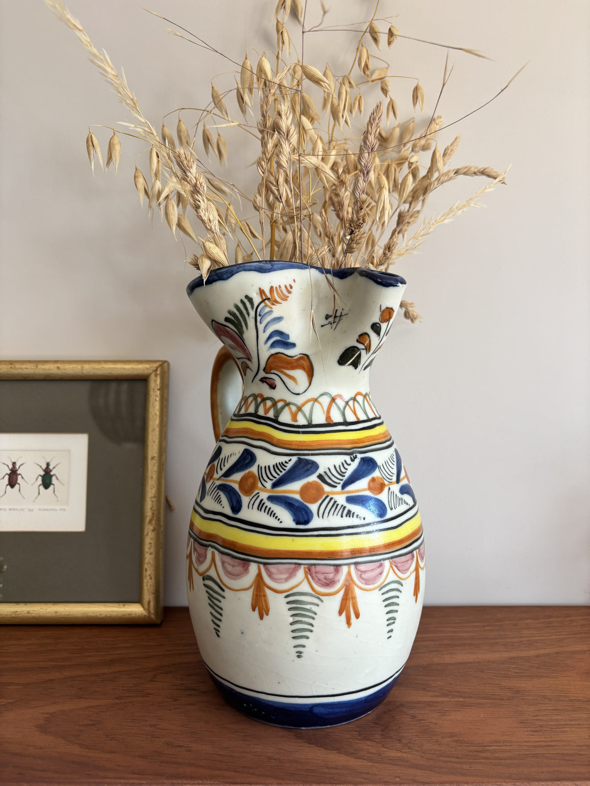A large Spanish stoneware pitcher featuring vibrant colourful motifs 