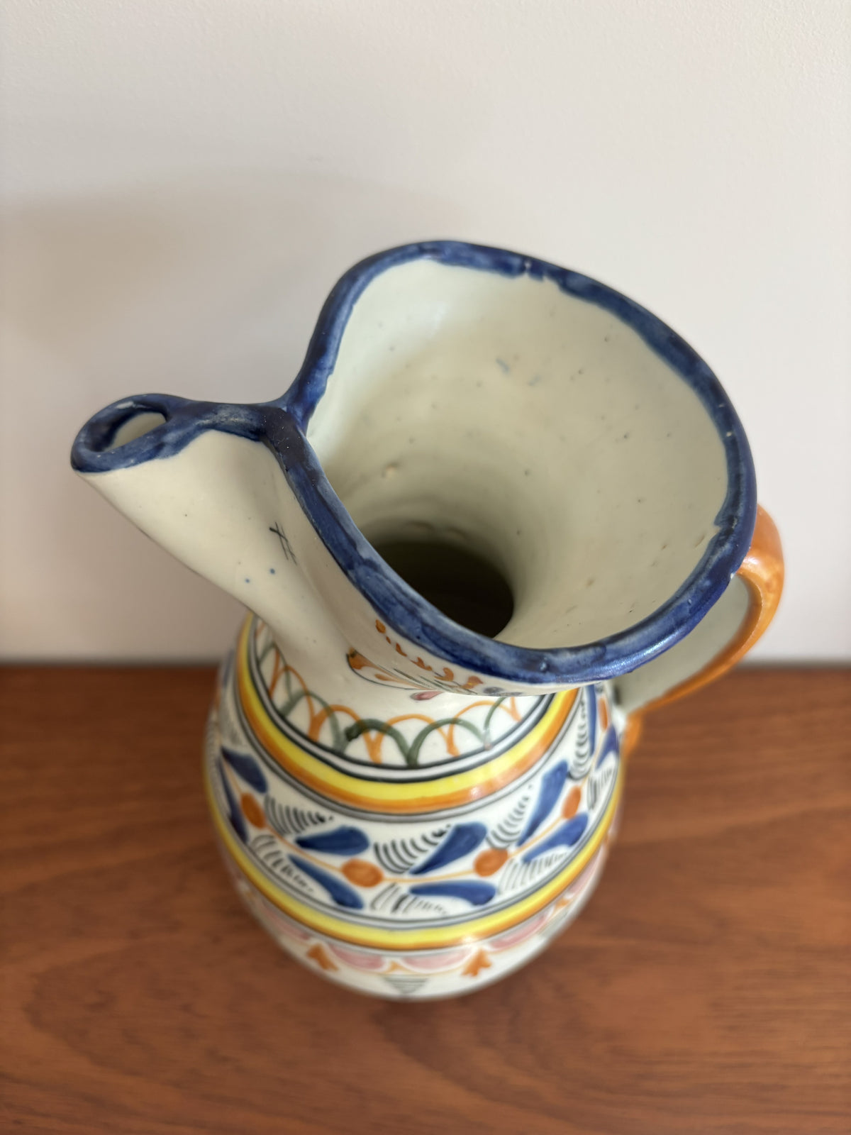 The top of a large Spanish stoneware pitcher featuring vibrant colourful motifs