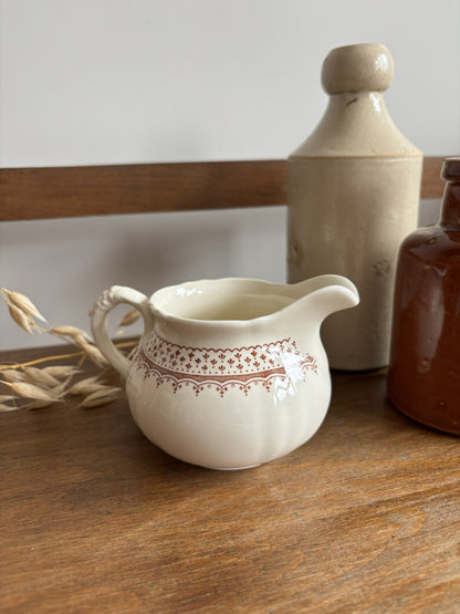A cream-colored Mason's ceramic creamer pitcher with a brown floral pattern