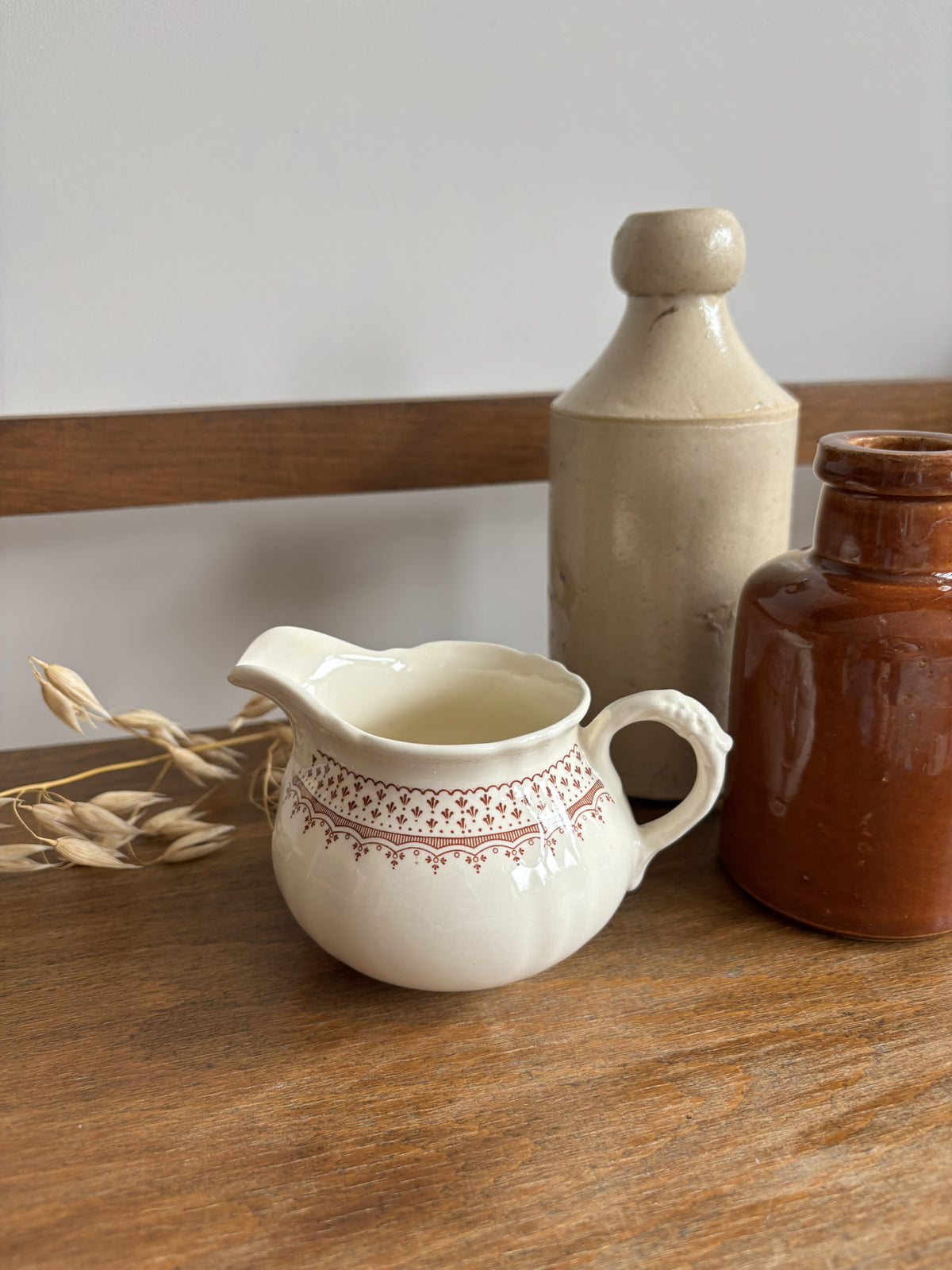 A cream-colored Mason's ceramic creamer pitcher with a brown floral pattern