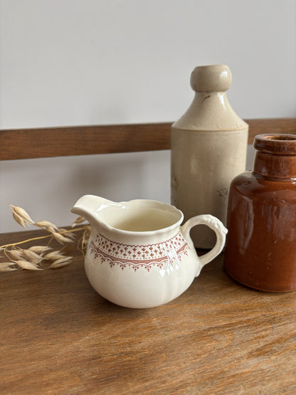 A cream-colored Mason's ceramic creamer pitcher with a brown floral pattern