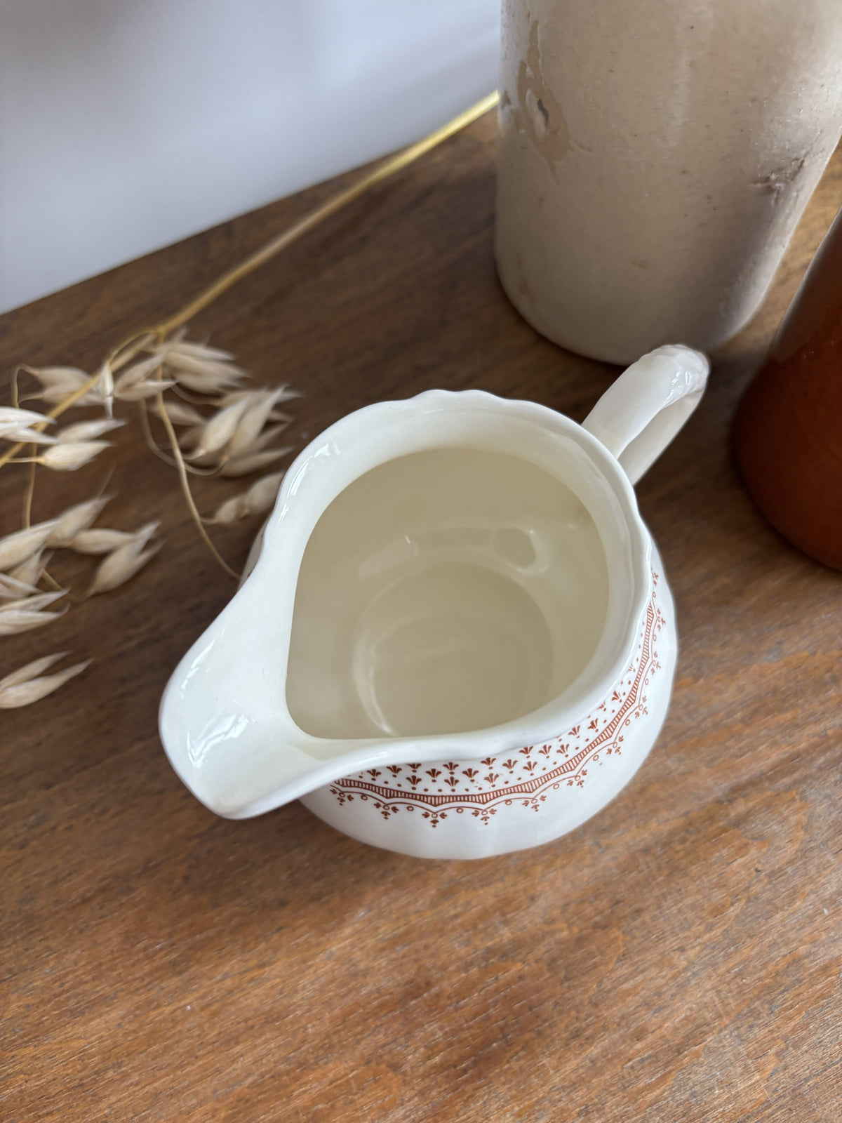 A cream-colored Mason's ceramic creamer pitcher with a brown floral pattern