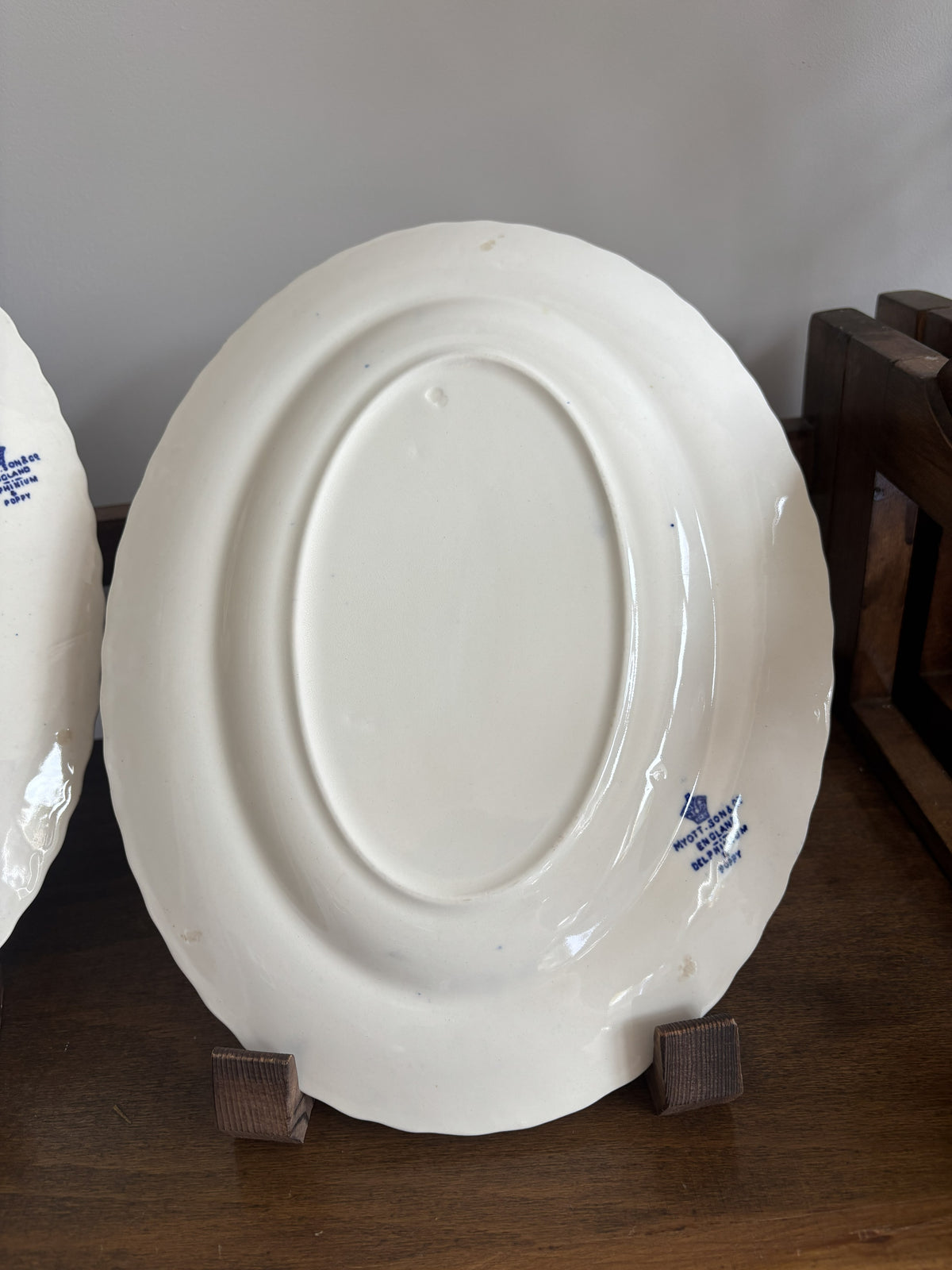 The back of a white ceramic plate showing the blue printed 'Myott Sons Co England Delphinium & Poppy' words
