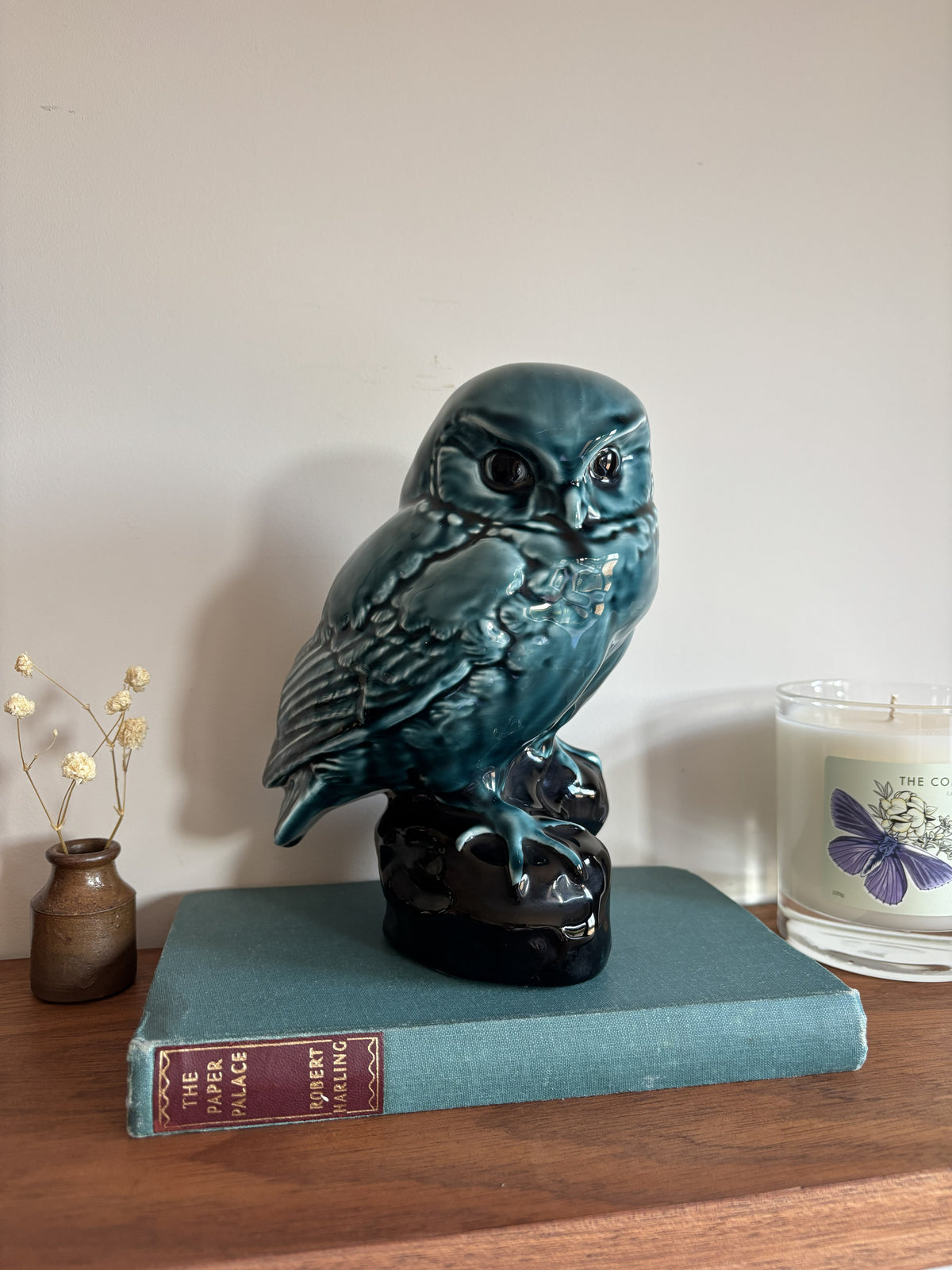 A vintage Poole Pottery glossy teal-blue ceramic owl figurine perched on a dark base.