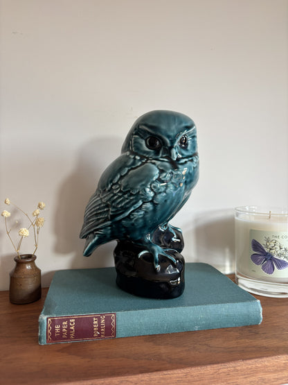 A vintage Poole Pottery glossy teal-blue ceramic owl figurine perched on a dark base.