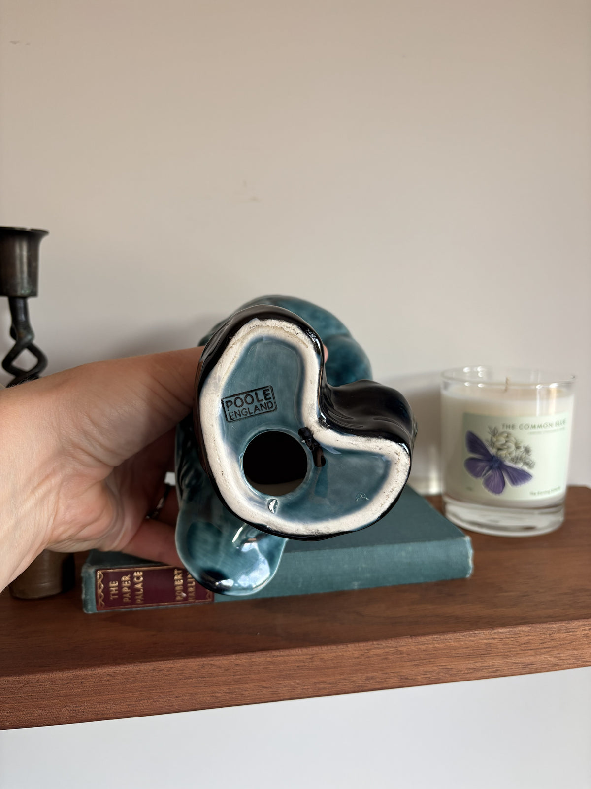 The base of a vintage Poole Pottery glossy teal-blue ceramic owl figurine showing the words 'Poole England'
