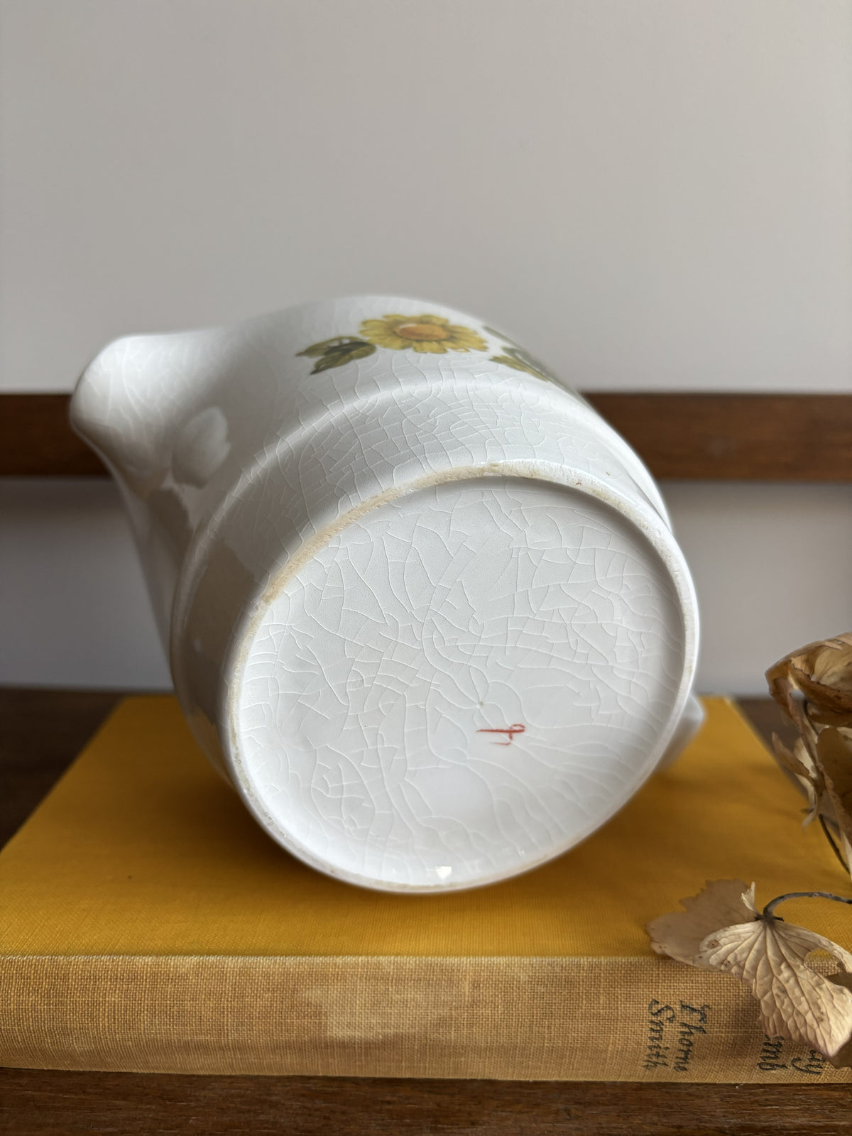 A vintage white sauce boat with a yellow floral display.  