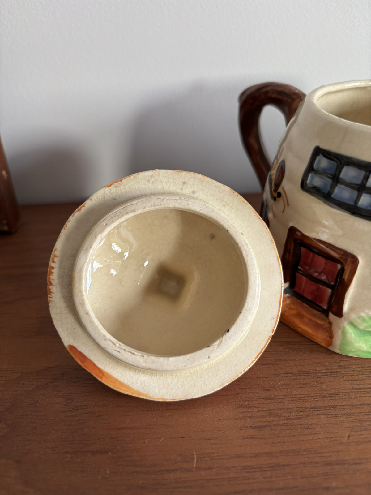 A close-up of a Suvesco ceramic lidded honey or sugar pot with a cream-colored glaze.