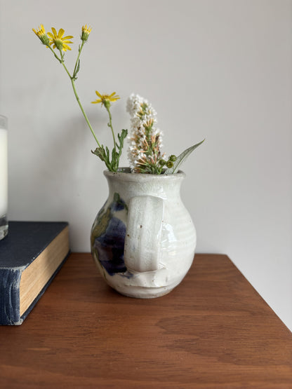 a small white bud vase