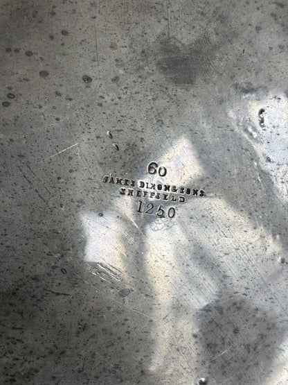 Close-up of a brushed metallic surface with stamped markings reading '60', 'James Dixon & Sons Sheffield', and '1250'